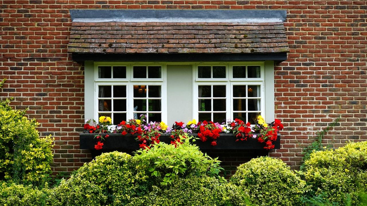 Red brick house with window with flower boxes