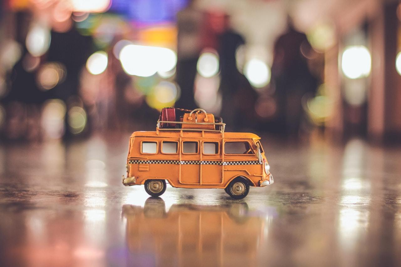 Toy bus with suitcase on its roof