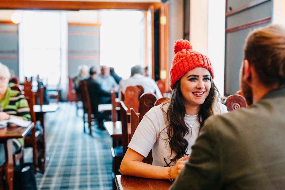 Girl in a red hat chatting with a man in cafe