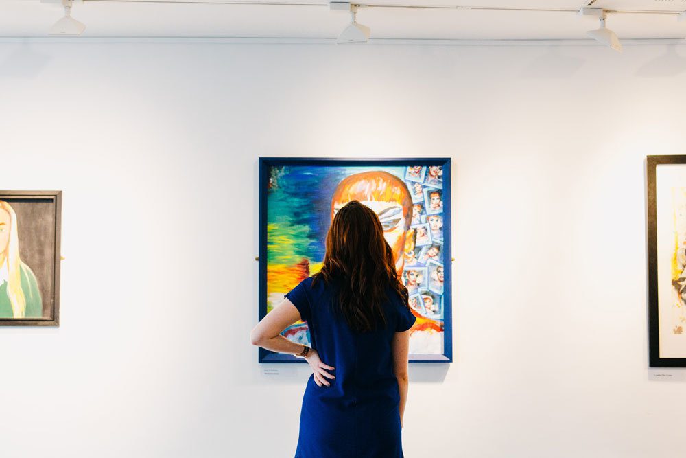 Woman looking at a painting in a gallery