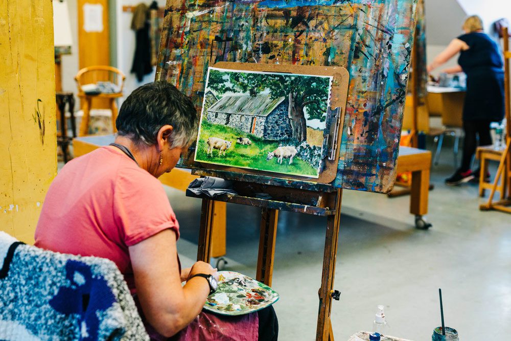 Woman painting in an art class at The Crescent