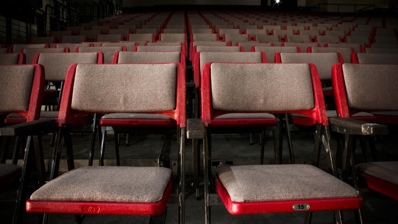 Empty fold up chairs in a dark room