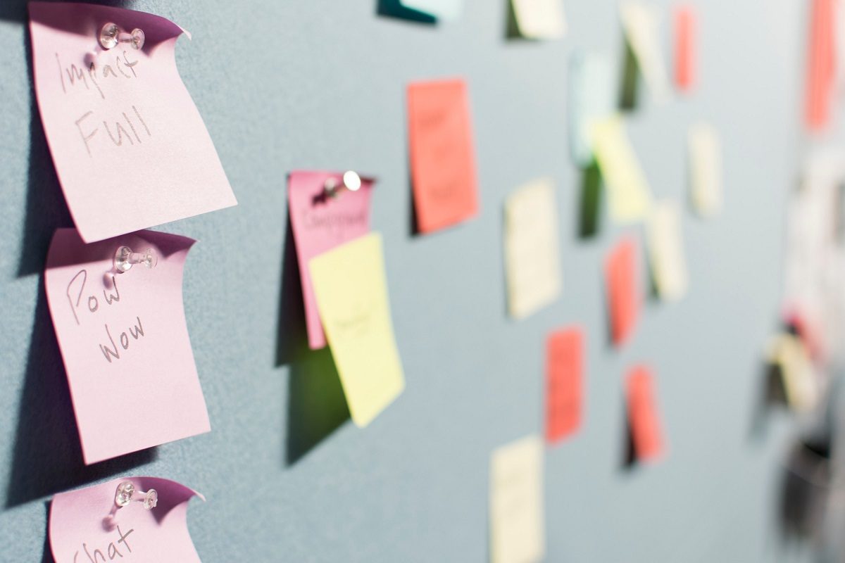 Post-it notes pinned onto a light blue pinboard