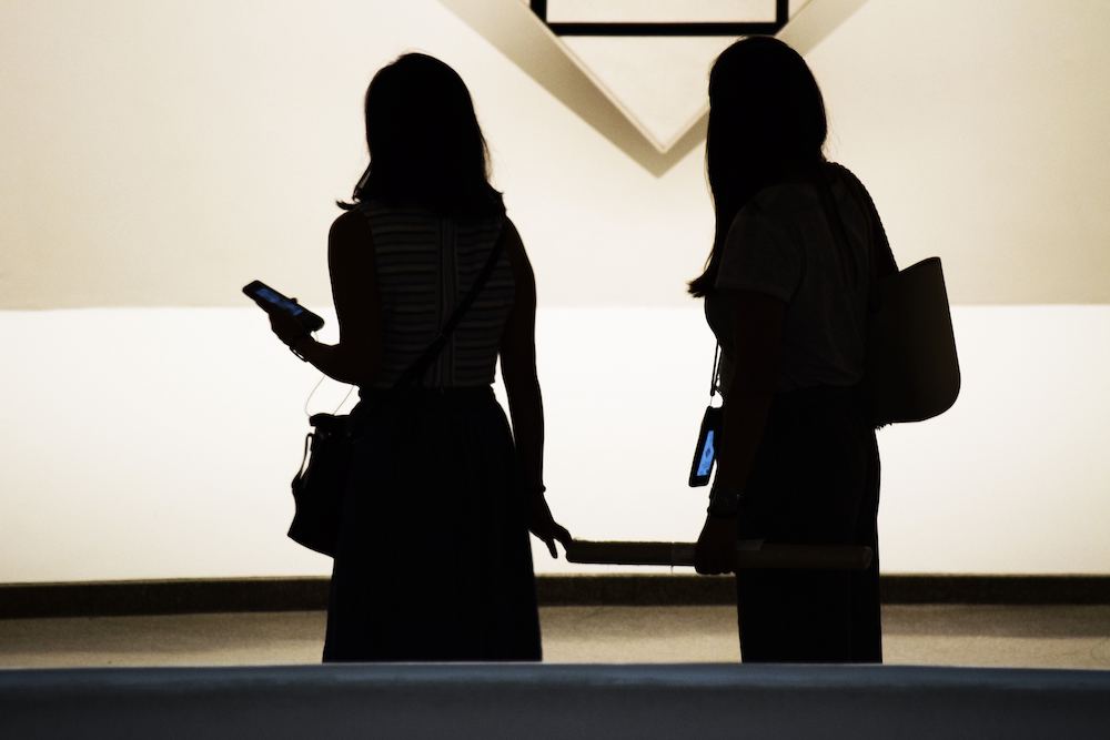 Two silhouettes of woman in an art gallery
