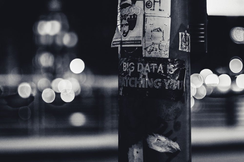 Black and white photo of a lamppost with sticker reading 'Big Data'