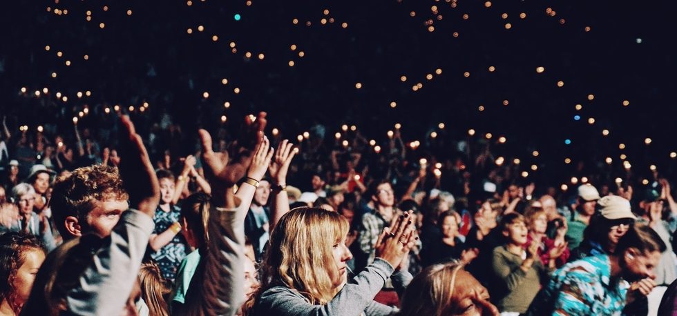 Crowd raising hands and clapping during performance