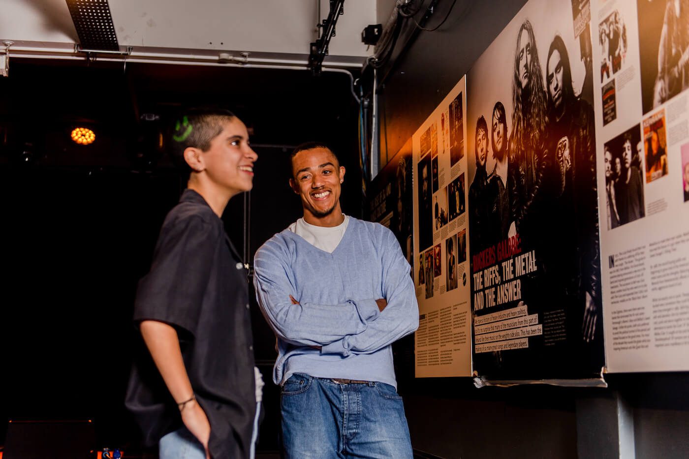 Young people standing in front of an exhibition panel
