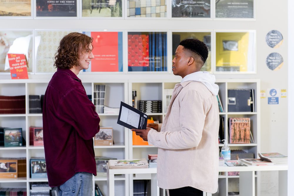 Two men chatting in an art gallery
