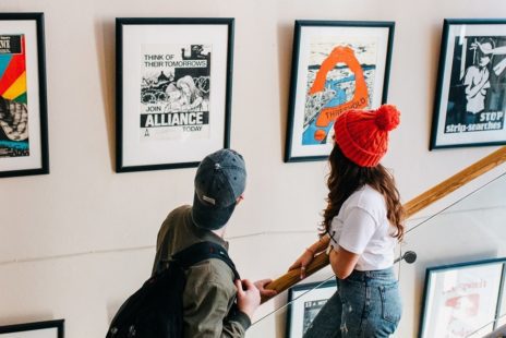 Two people looking at art on a wall