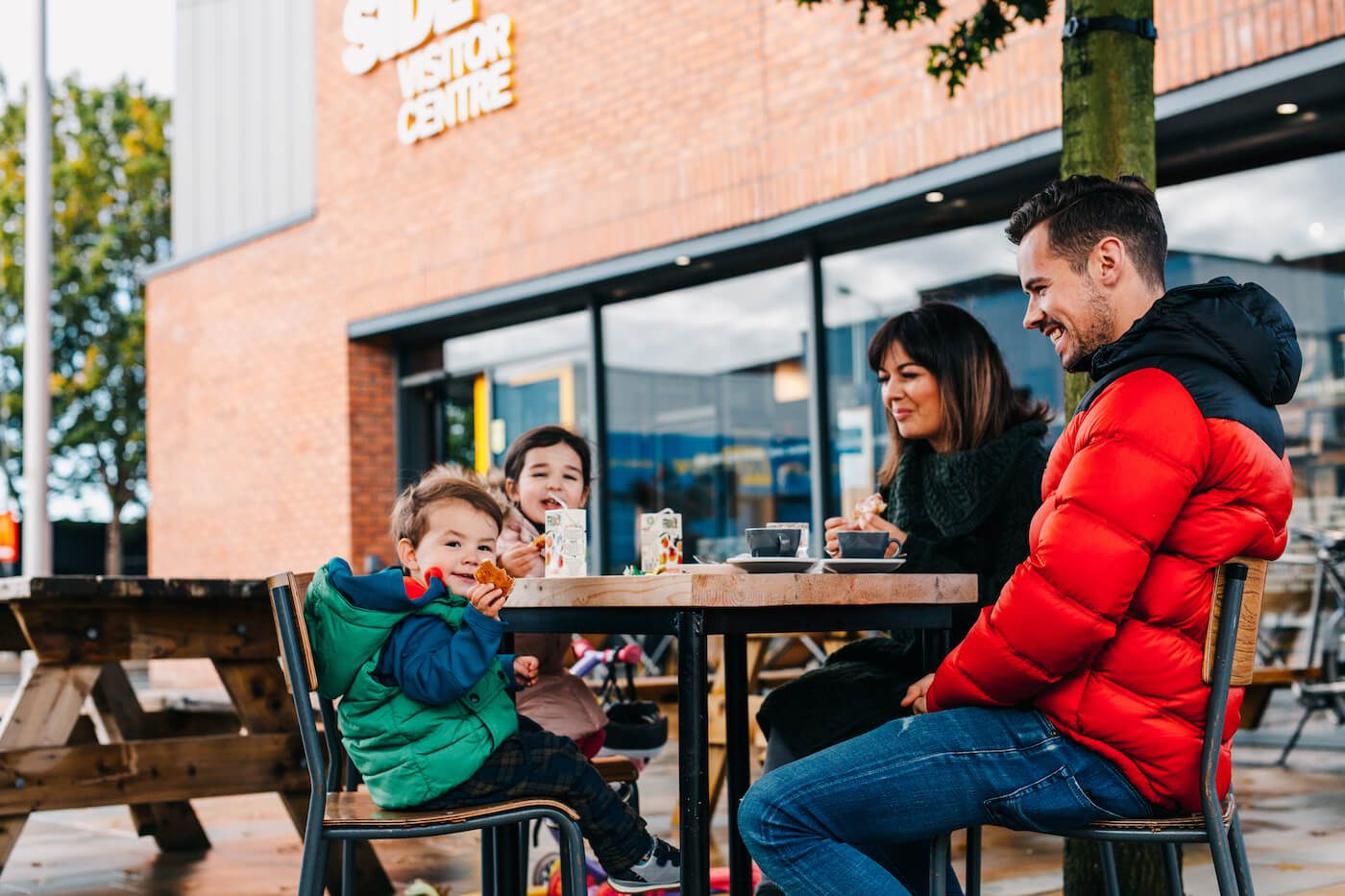 Family outside arts centre eating a picnic