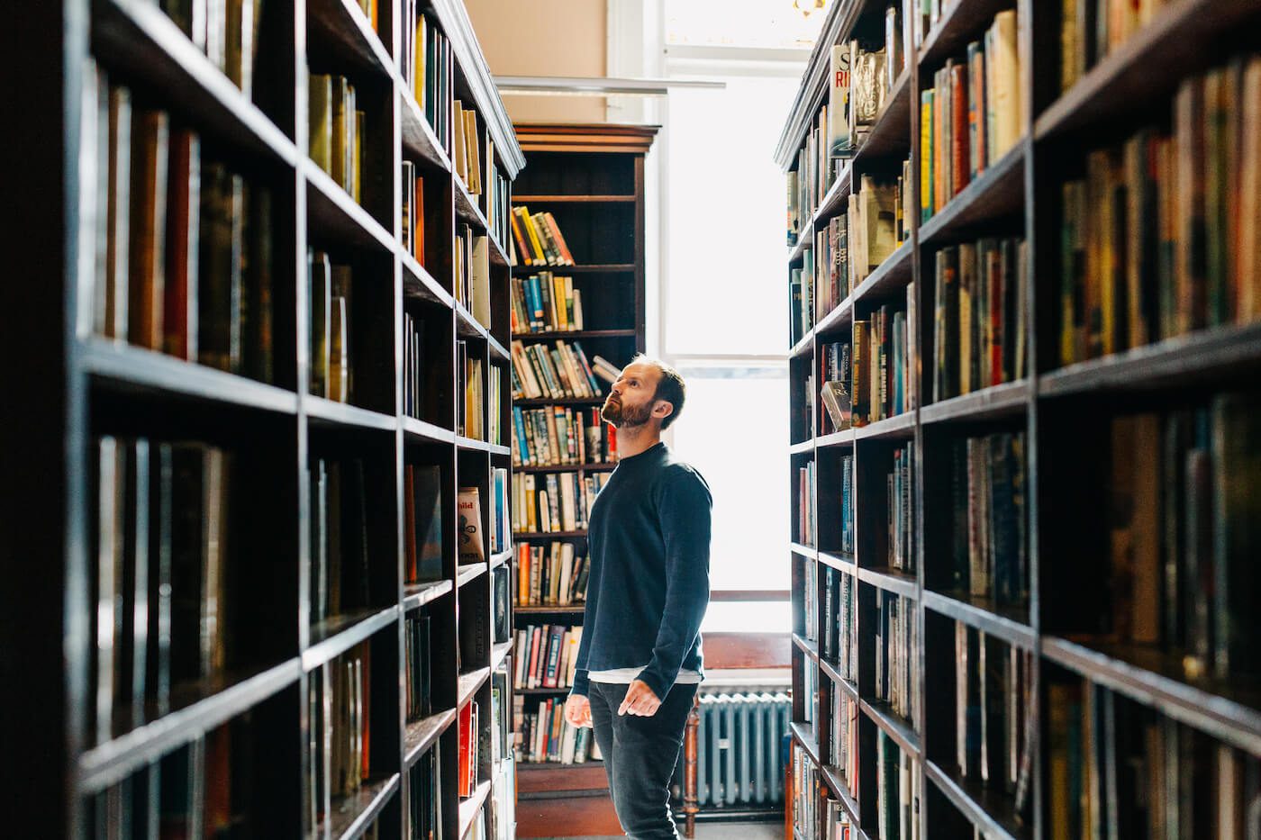 Man looking at books in library