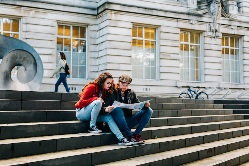 Couple reading map on steps