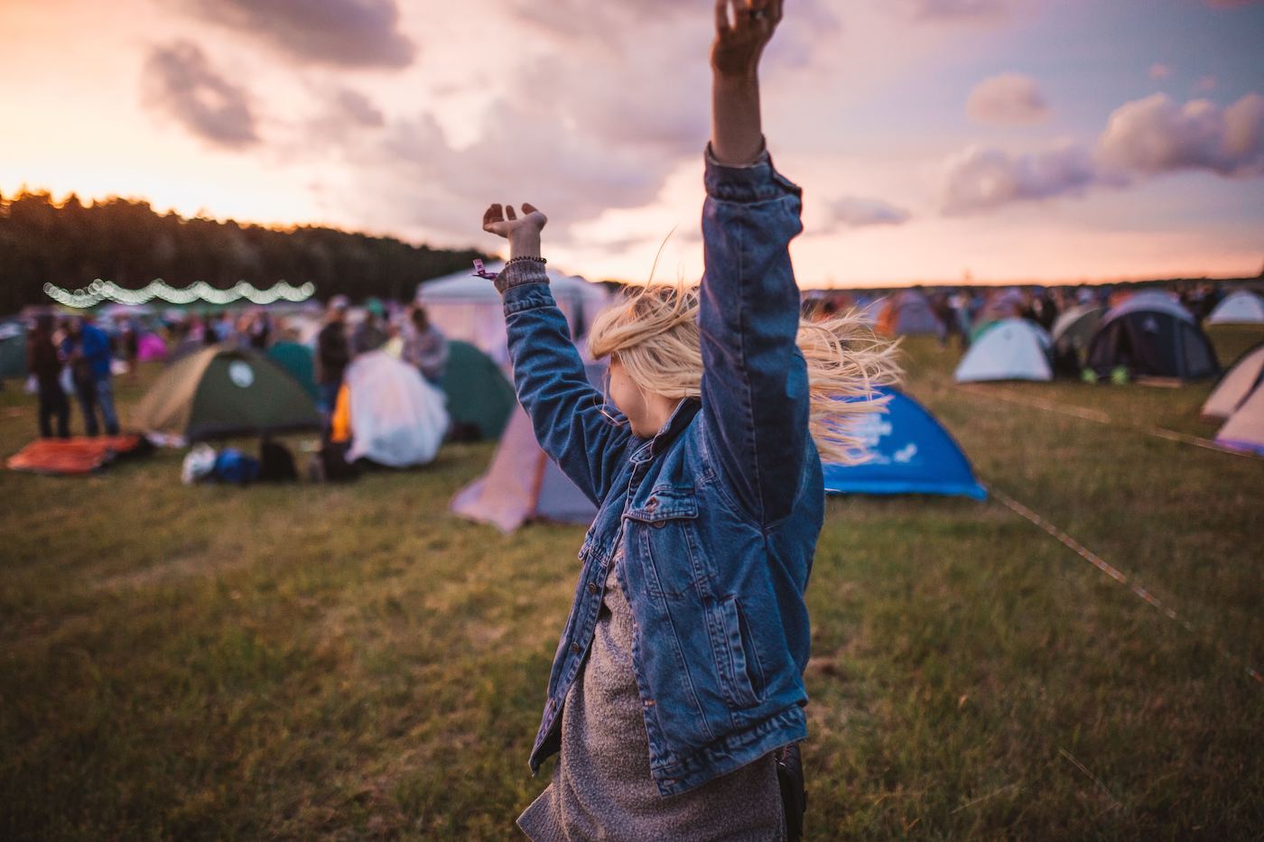 Women dancing in a field of tents at a festival