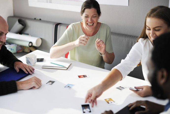 A group sitting around a table in a work setting and laughing